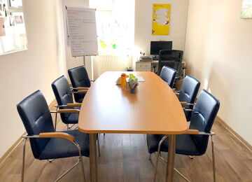 Ein Besprechungsraum in einer diabetologischen Praxis mit einem Tisch, Stühlen und Materialien für Diabetesberatung.