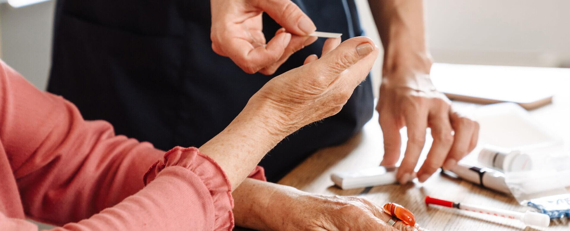 Eine Ärztin misst den Blutzucker einer älteren Patientin in einer diabetologischen Praxis für Diabetes-Management.