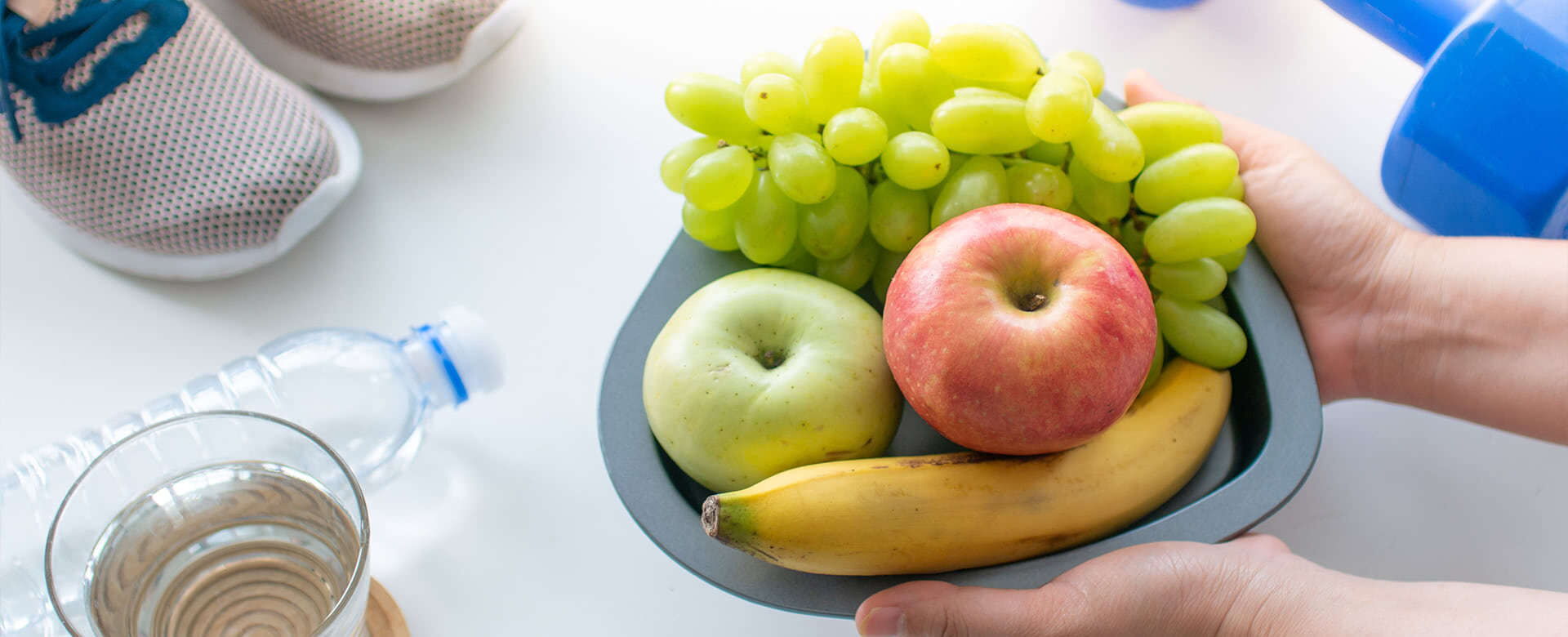 Eine Hand hält eine Schüssel mit frischem Obst, ideal für eine gesunde Ernährung in einer diabetologischen Praxis. | © Name
