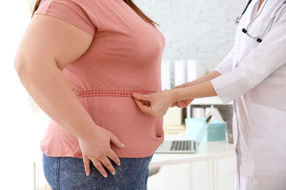 Eine Ärztin misst den Taillenumfang einer übergewichtigen Frau in einer diabetologischen Praxis zur Diabetesprävention.
