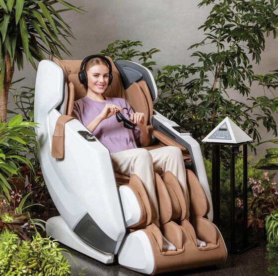 Eine entspannte Frau sitzt in einem Massagestuhl in einer Diabetologischen Praxis, umgeben von Pflanzen.