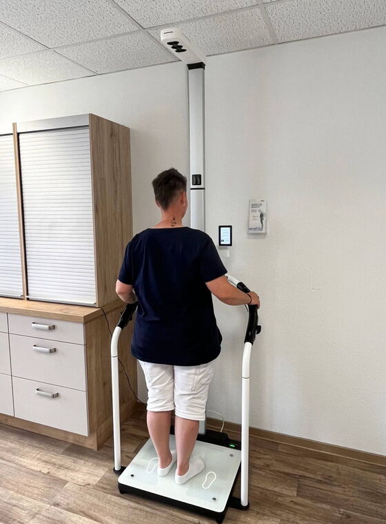Eine Patientin steht auf einer Waage in der diabetologischen Praxis zur Messung für die Diabetesdiagnostik.